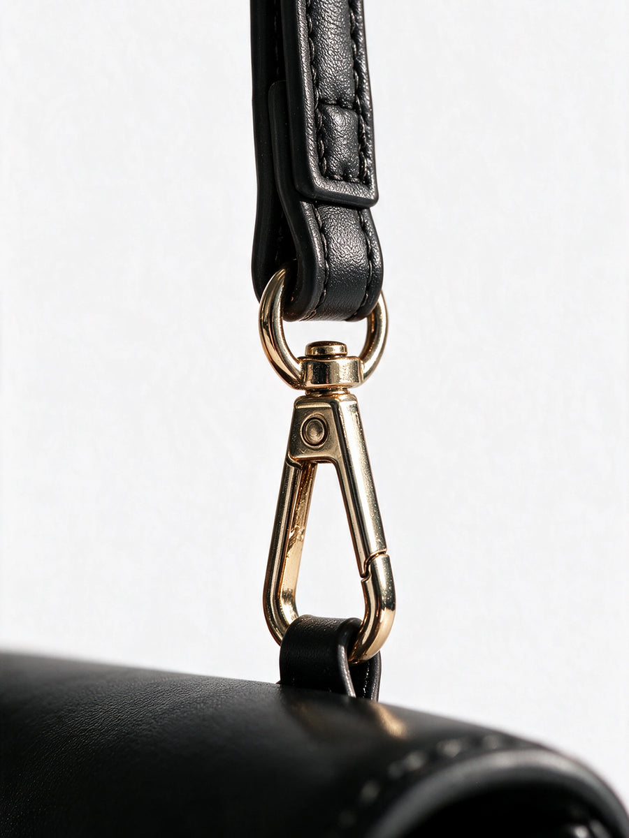 Gold clasp and wrist strap detail of the black Sentir travel pouch