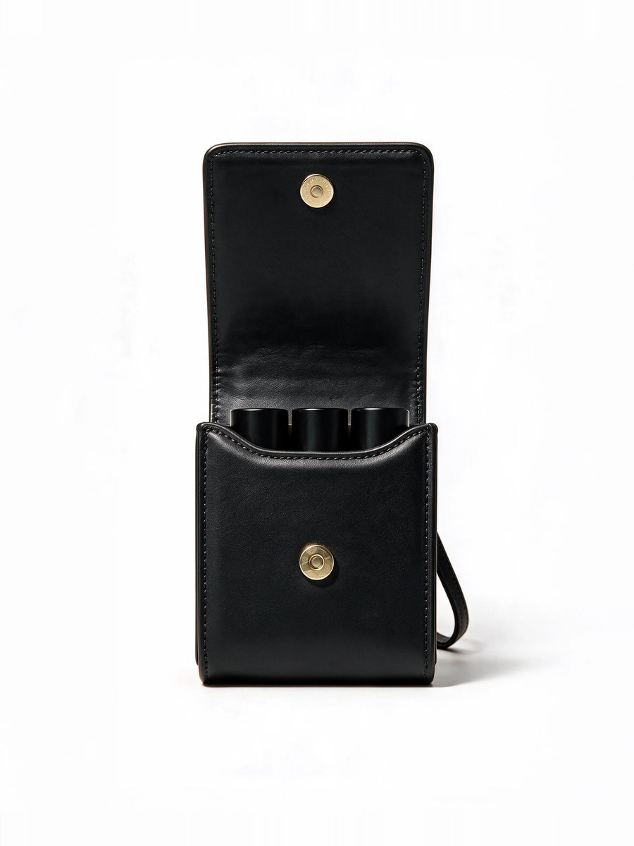 Sentir travel pouch in black, open and holding three 10 ml perfume bottles