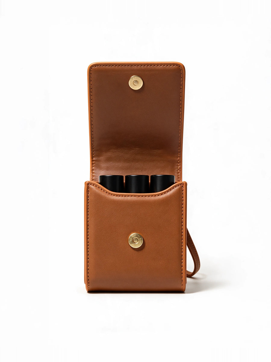 Sentir travel pouch open, holding three 10 ml perfume bottles